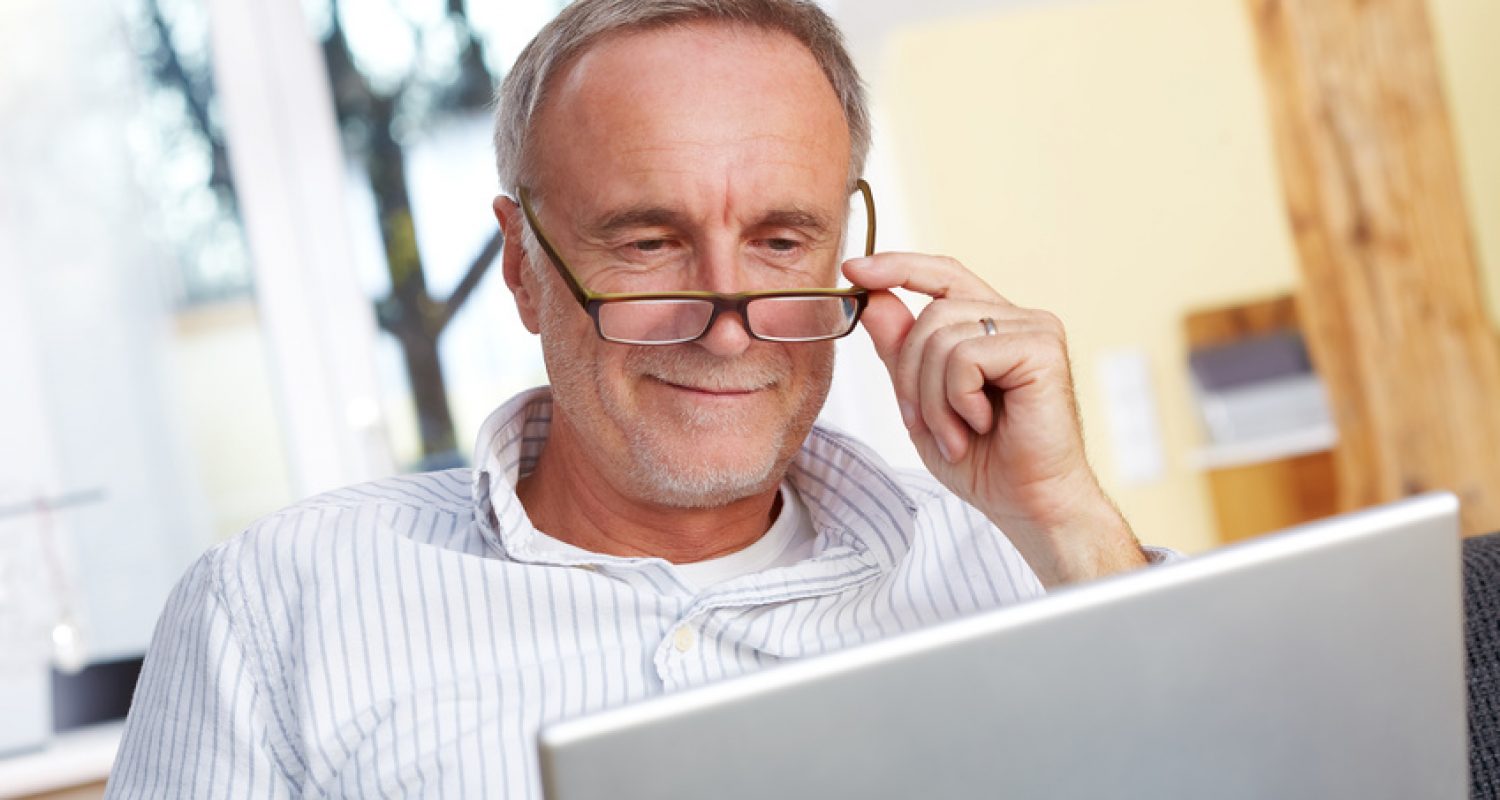 mature man with laptop and eyeglasses